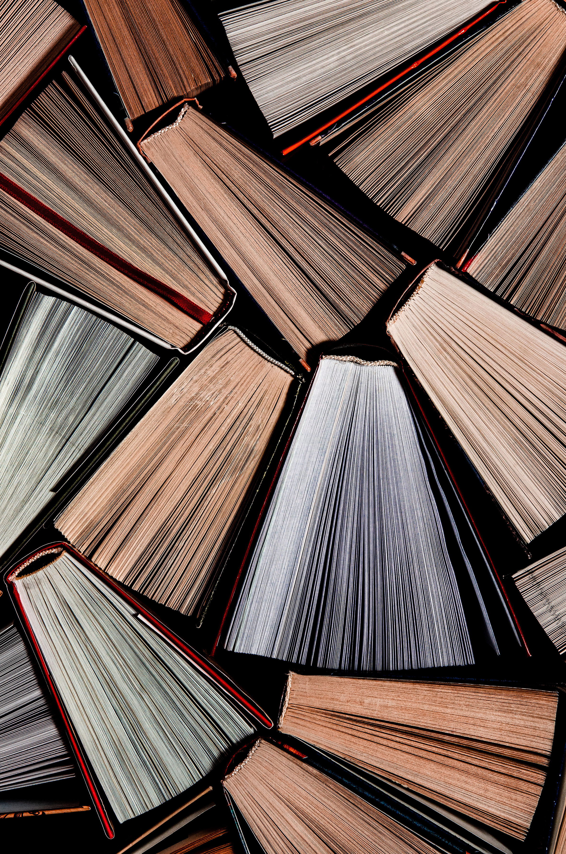 Books. Lots of colourful thick open books stand on a dark background. ready to read